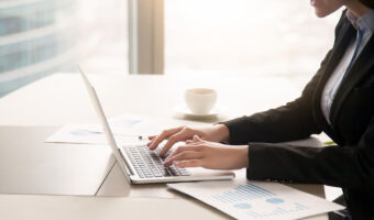 businesswoman-working-with-diagrams-at-office-using-laptop-close-up-1_0